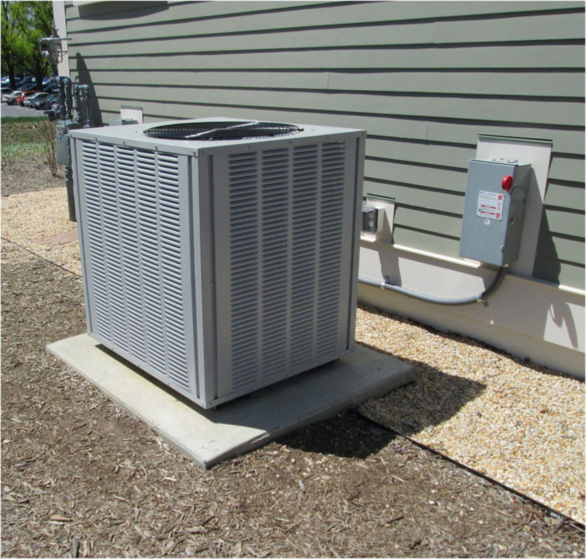 A large air conditioner sits outside of a building