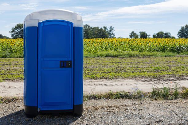 Blue portable restroom in nature.