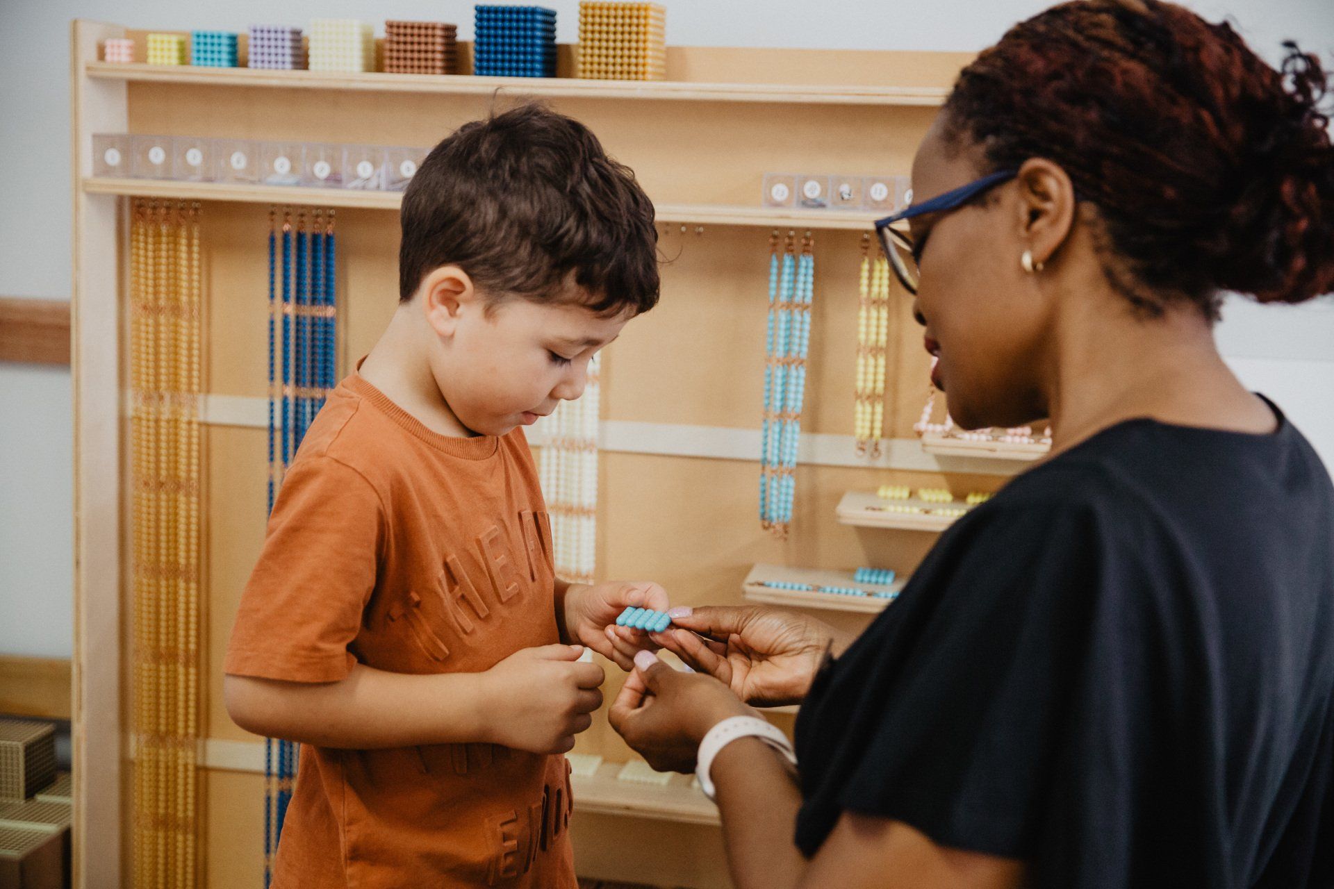 A woman assists a young boy with a toy at Sagewood Joondalup Campus Childcare Centre.
