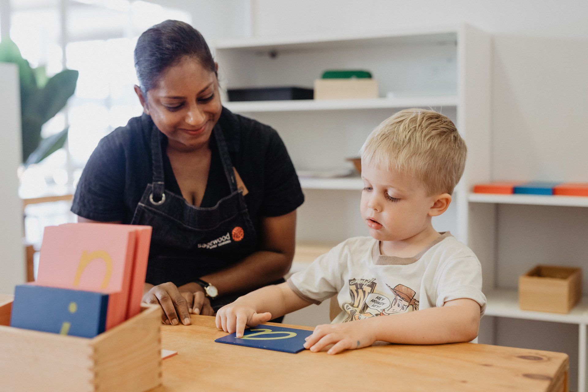 A woman and a child engaged in a fun wooden puzzle activity at Sagewood Joondalup Campus Childcare Centre.