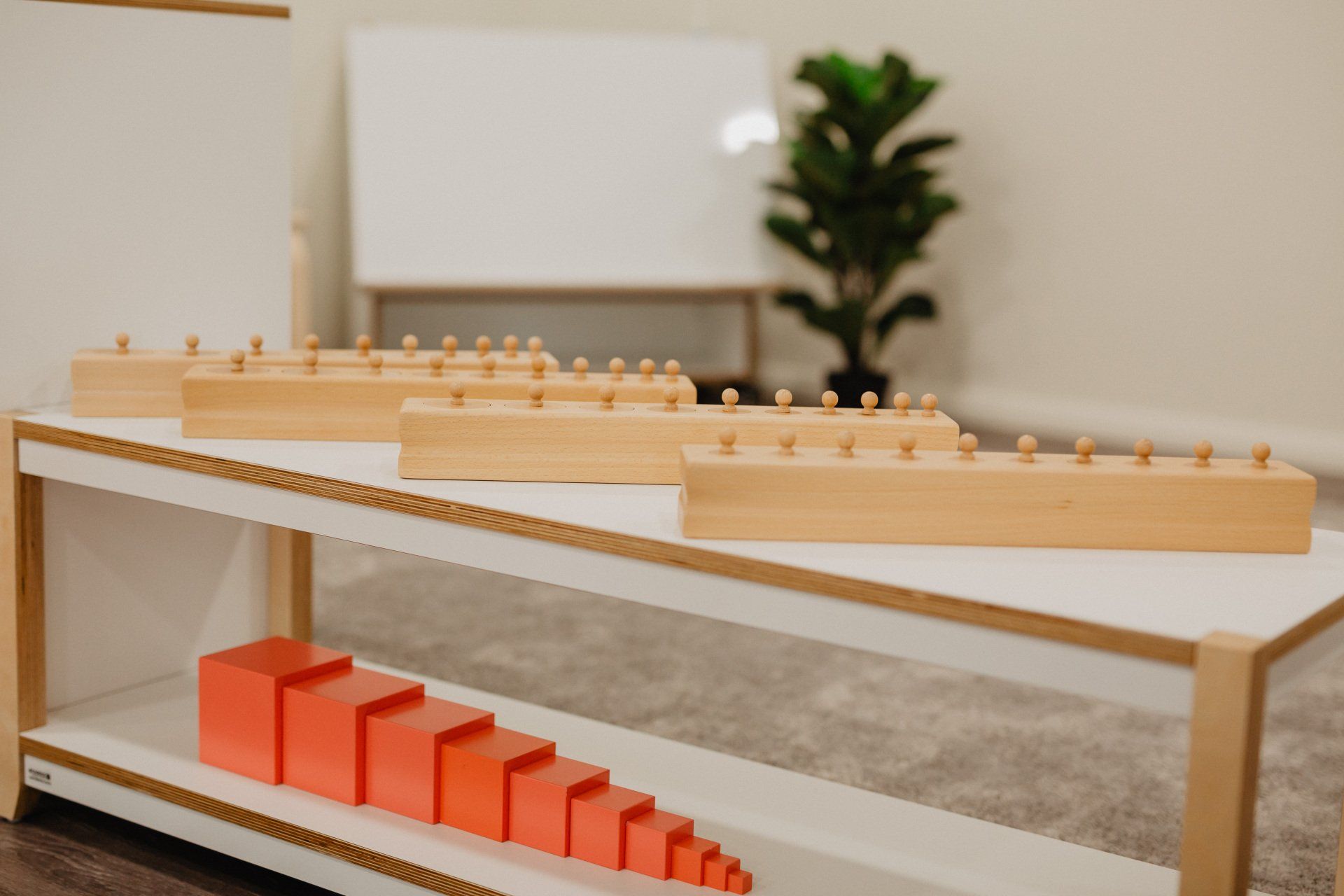 A table with colorful wooden blocks beside a whiteboard at Sagewood Canning Vale Campus Childcare Centre.