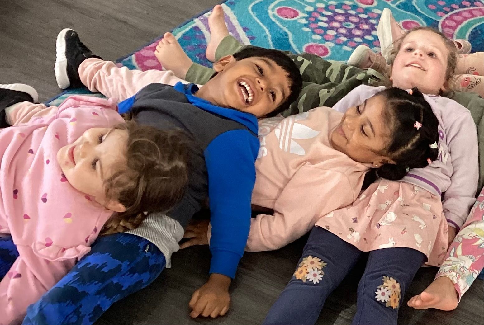 Children enjoying playtime together on a cozy rug at Sagewood Elma Campus Childcare Centre.
