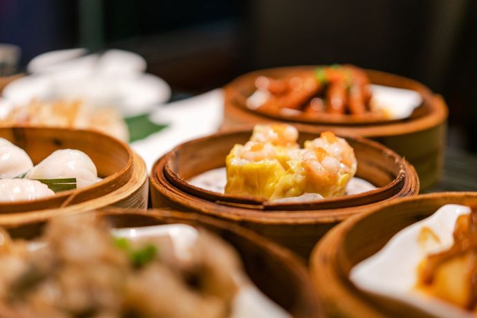 Un primo piano di dim sum in cestini di legno su un tavolo.