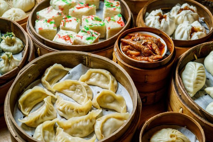 Una varietà di dim sum in cestini di legno su un tavolo.