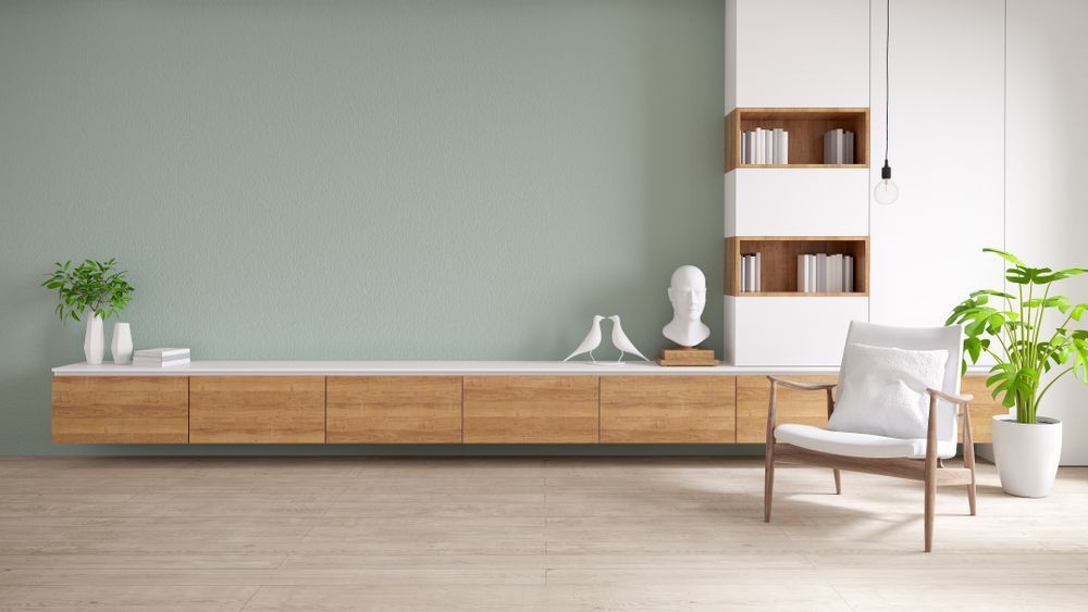 A Living Room With a Chair, Shelf, and Green Wall — Cairns Floors and More In Gordonvale, QLD