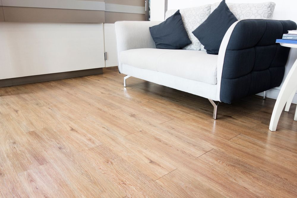 A Living Room With a Wooden Floor, a Couch, and a Table — Cairns Floors and More In Mount Sheridan, QLD