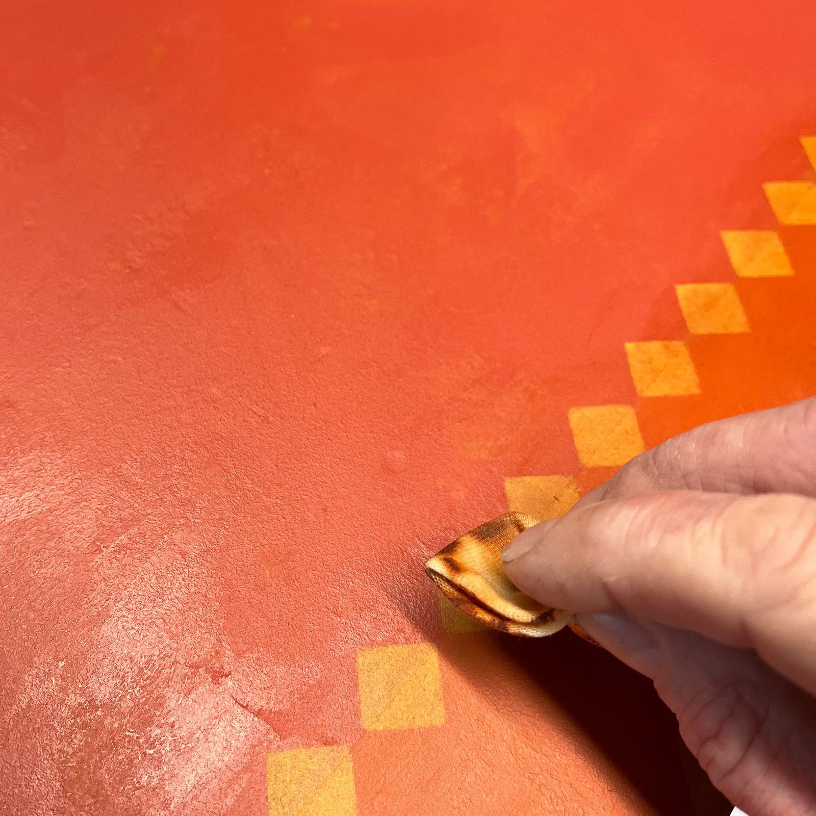 Helen Bateman rubbing oil based burnt sienna over the ochre stencil on the carnival chest.