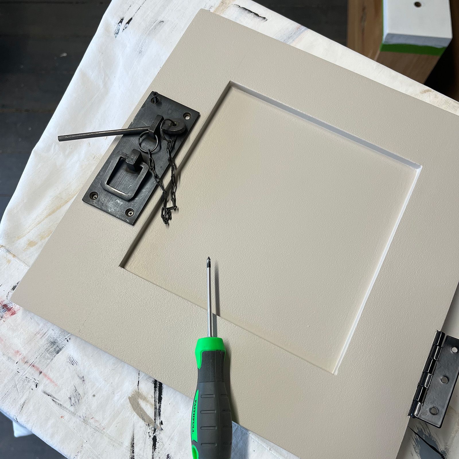 Latches being screwed back on chinese sideboard doors in the Edinburgh studio.