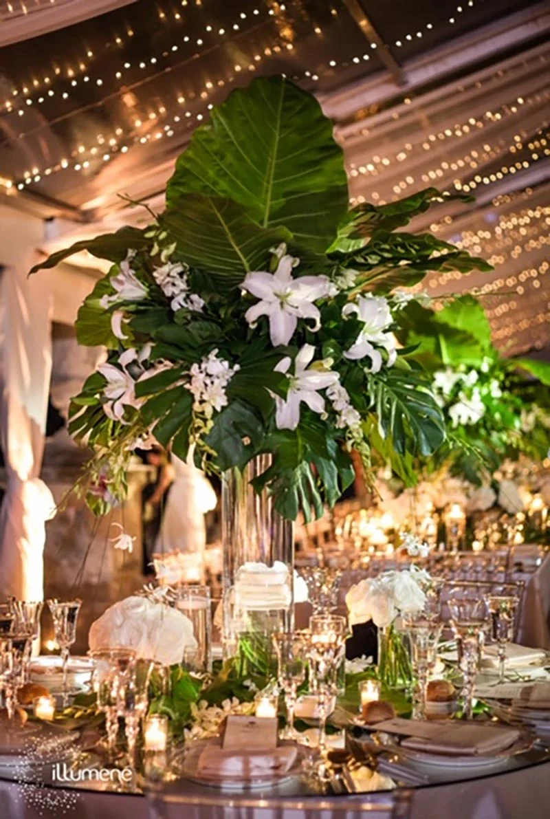 Wedding table setting with tall floral arrangement.