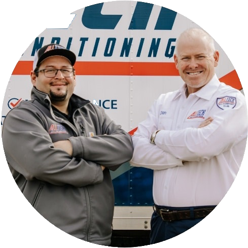 Two men are posing for a picture in front of a truck that says conditioning