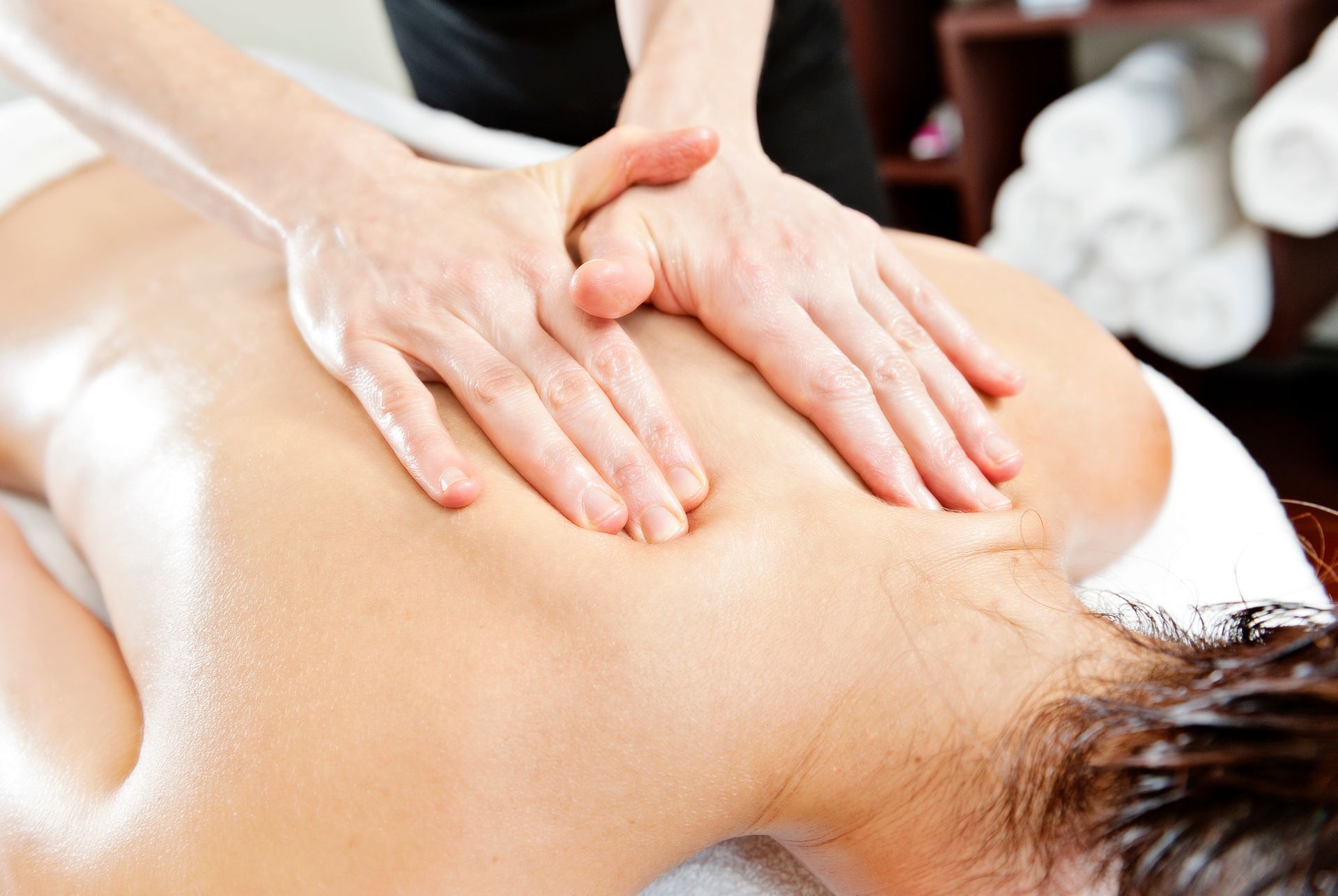 Hands massaging a person’s back during a spa treatment