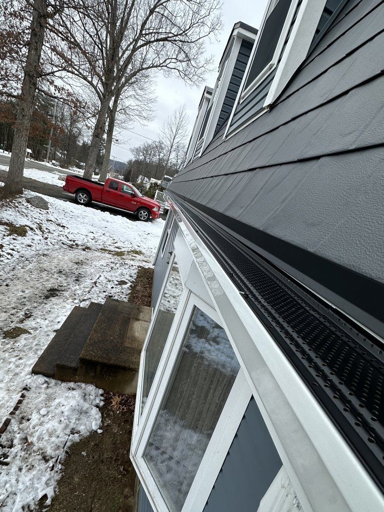 Snow-covered house exterior with a red truck parked along the street