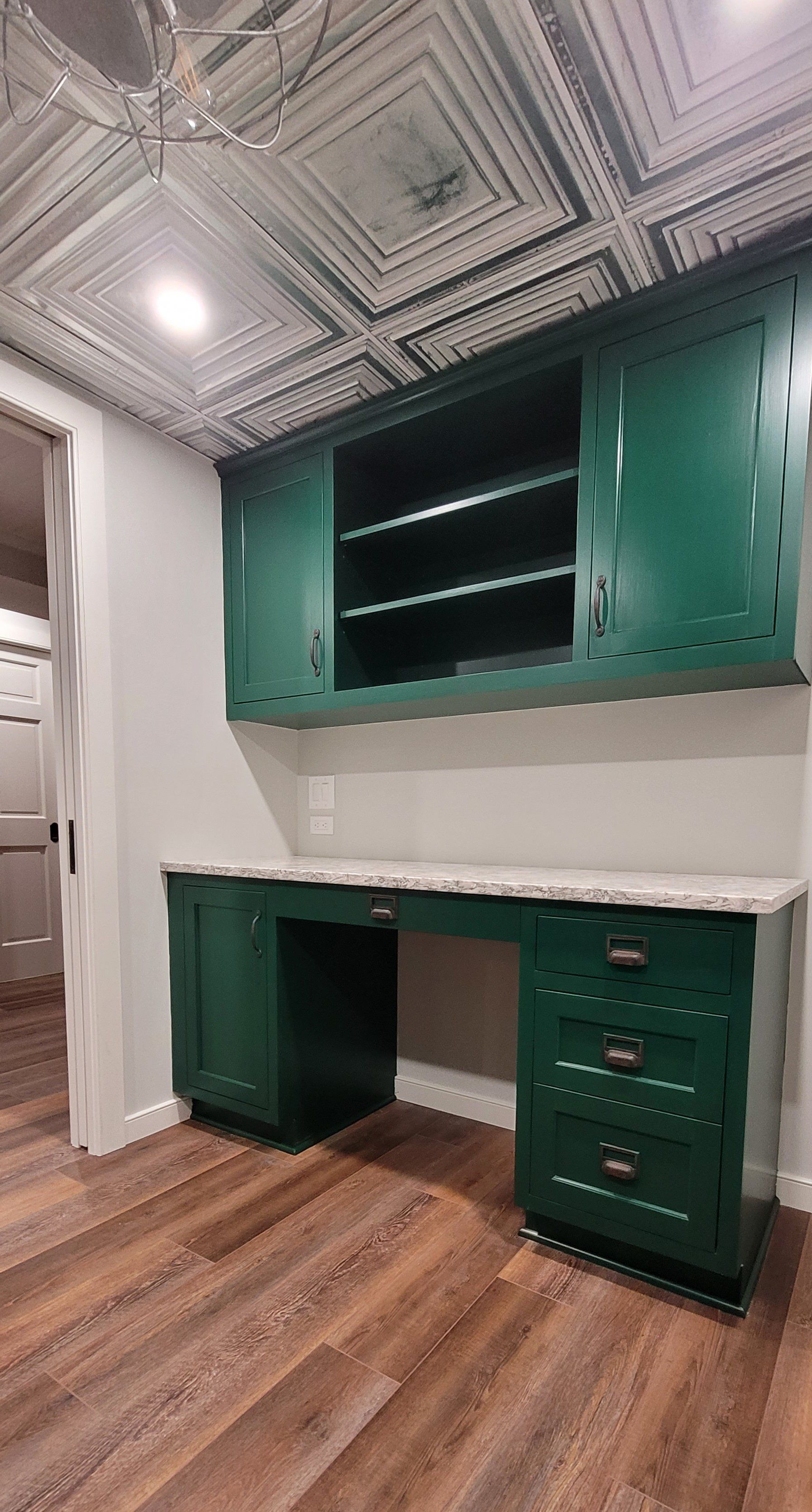 A room with green cabinets and a ceiling fan.