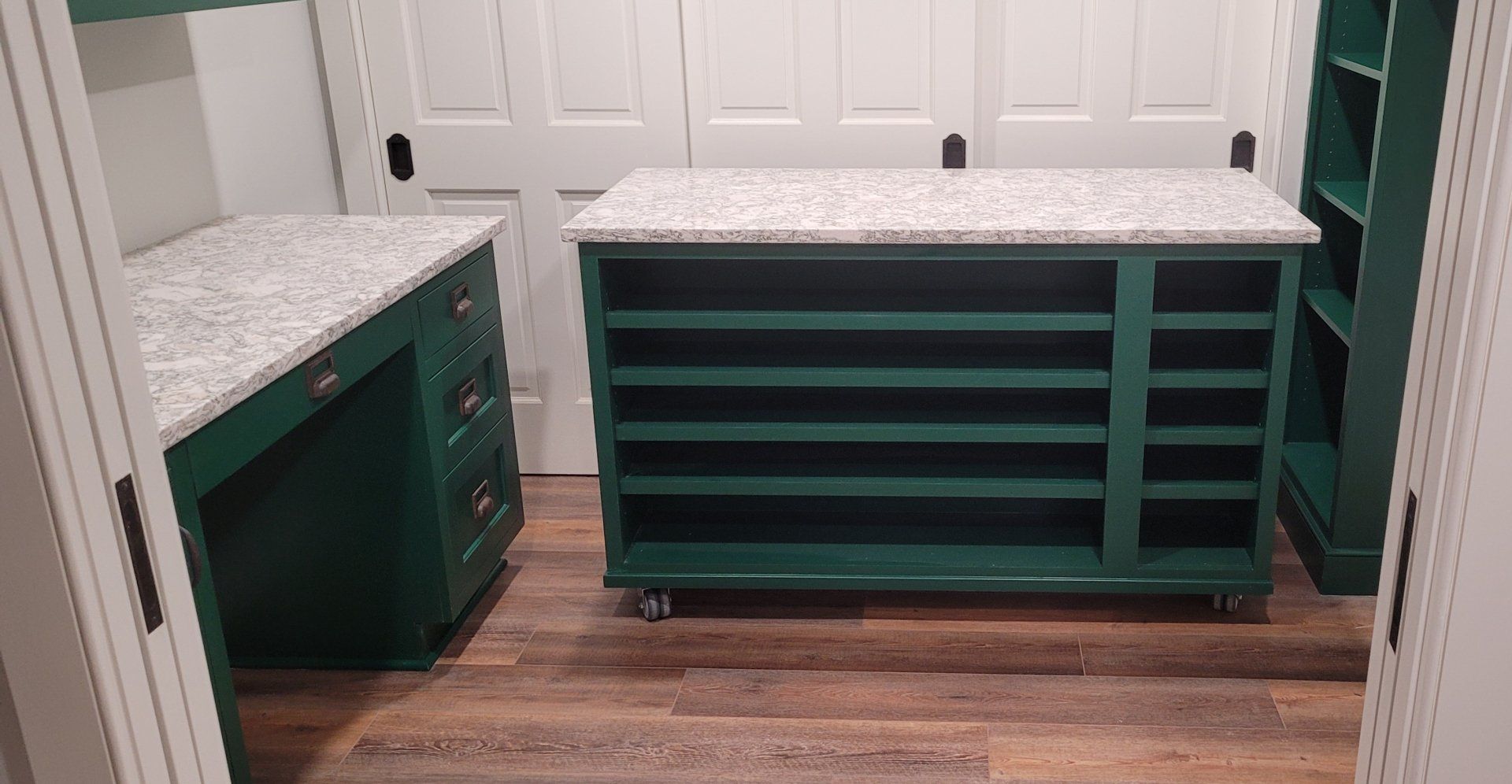 A room with green cabinets and a green table with wheels.