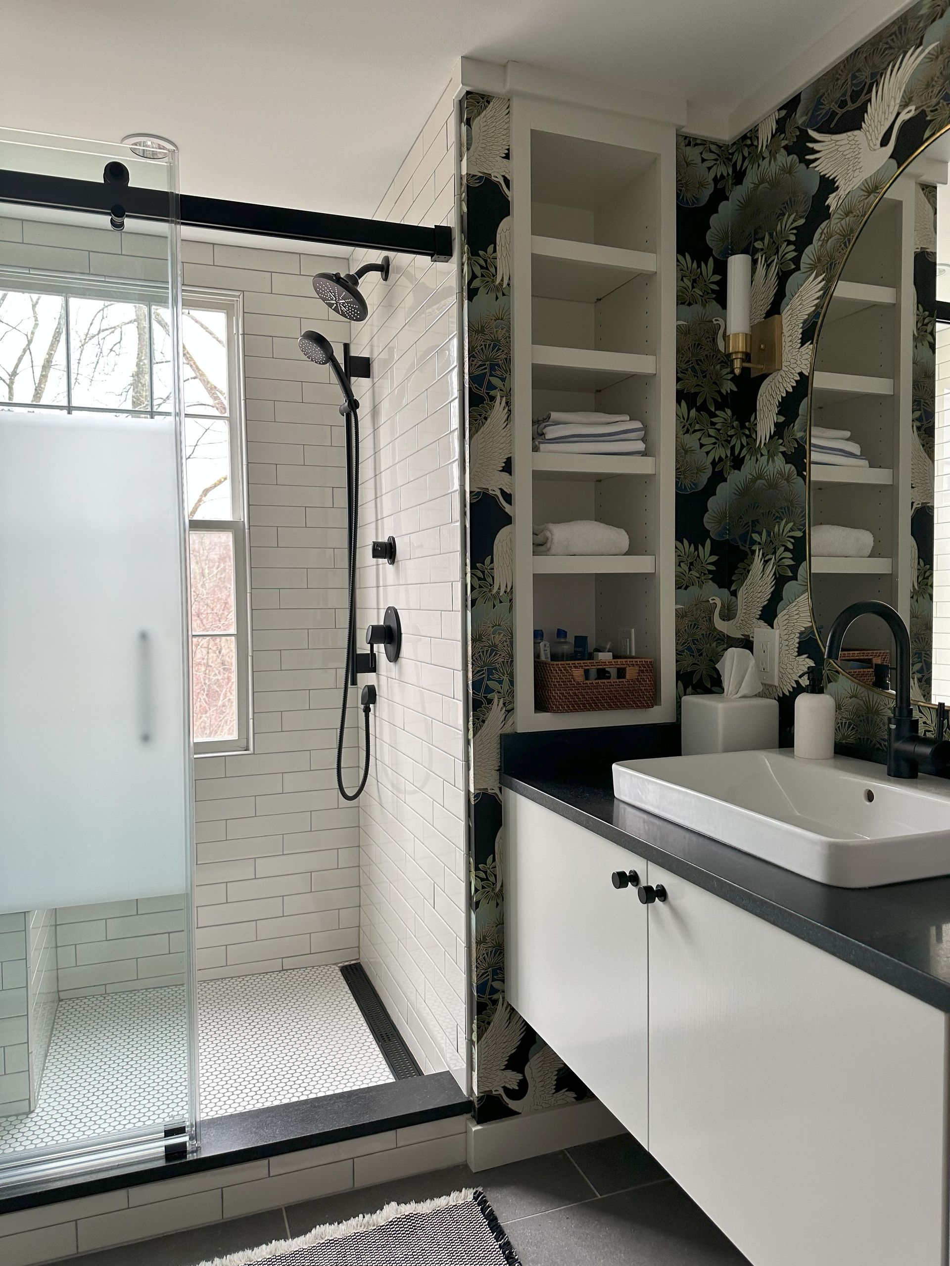 A bathroom with a sink , shower , and mirror.