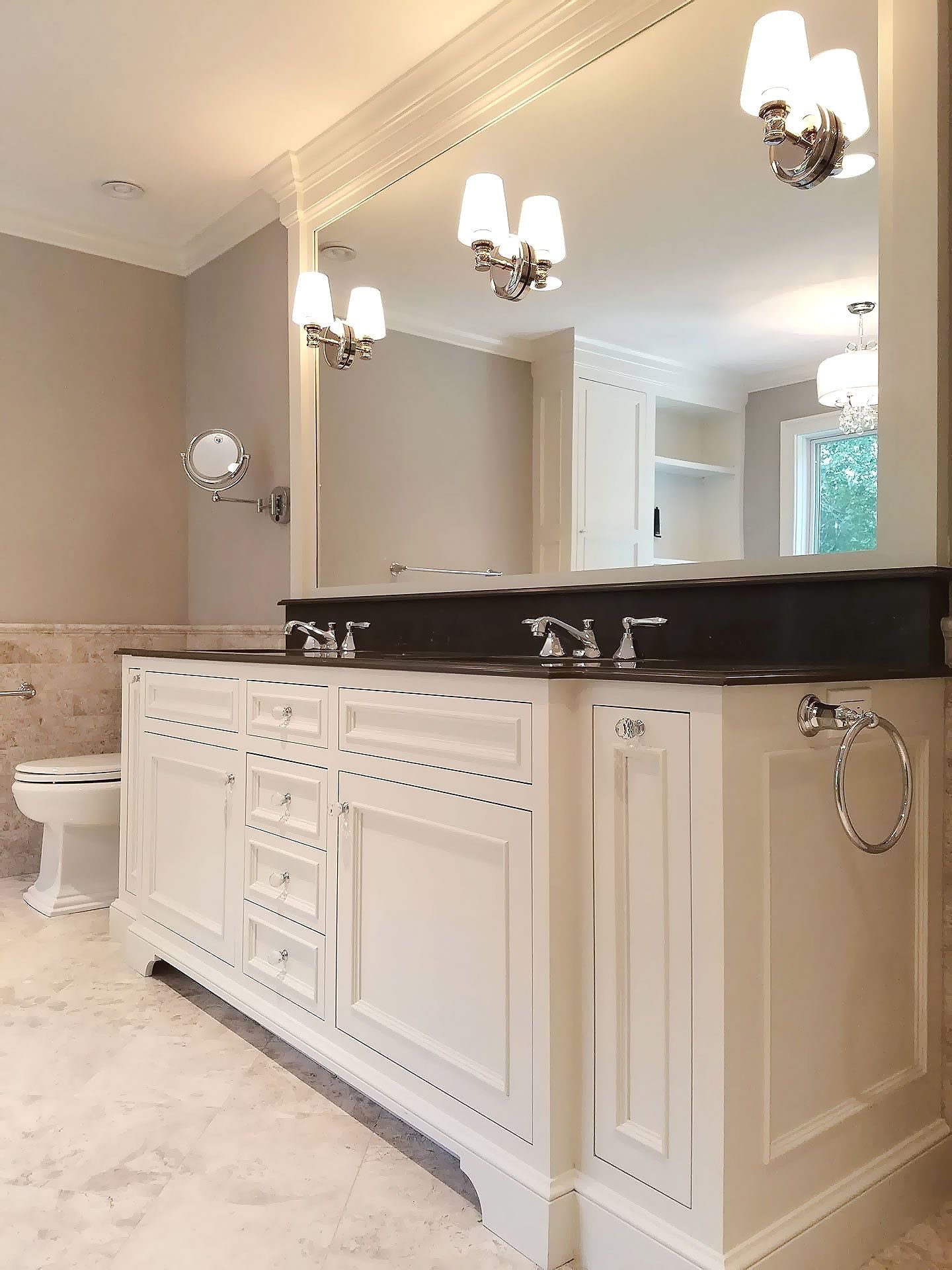 A bathroom with two sinks , a toilet , and a large mirror.