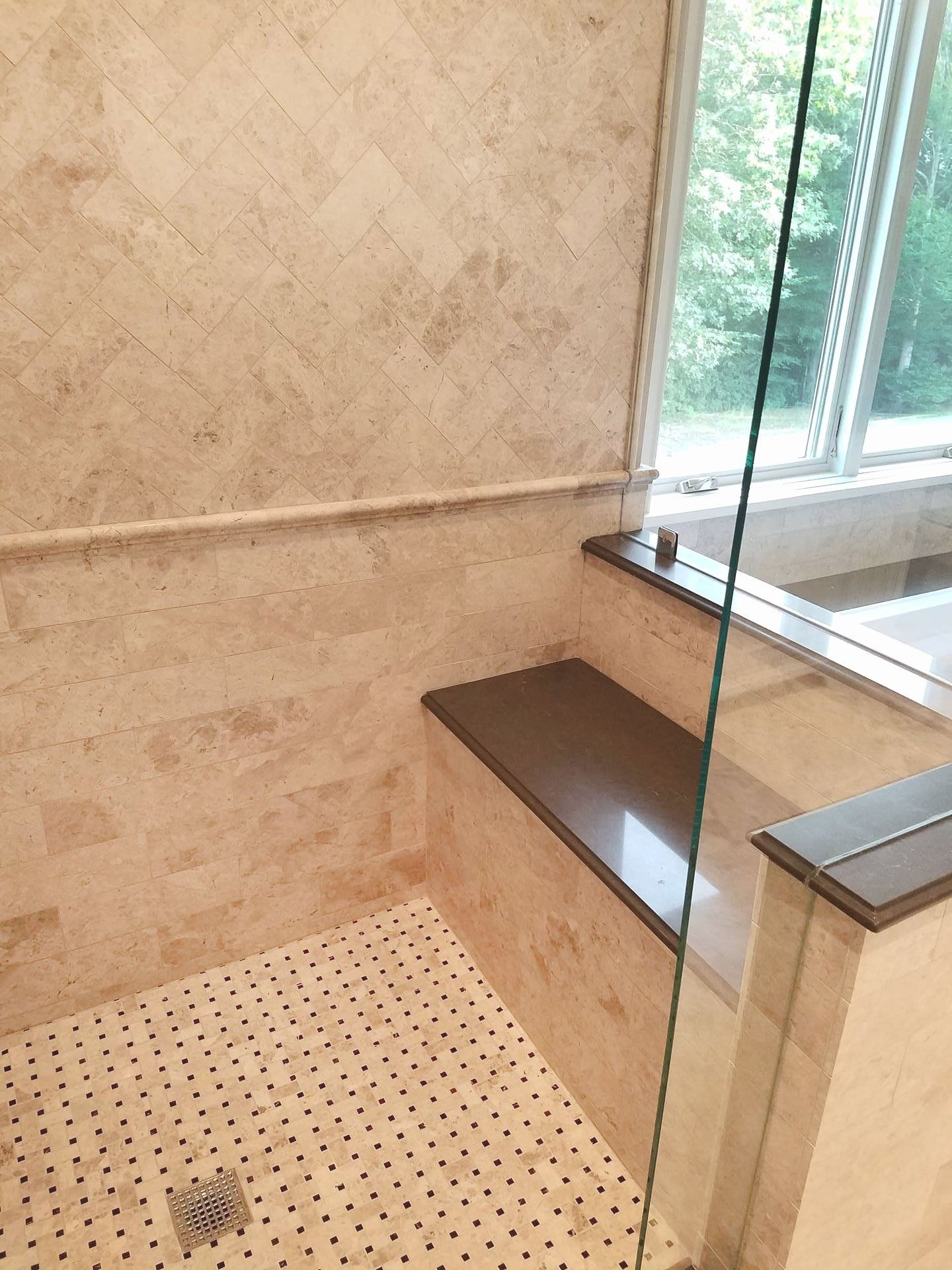 A bathroom with a walk in shower and a window.