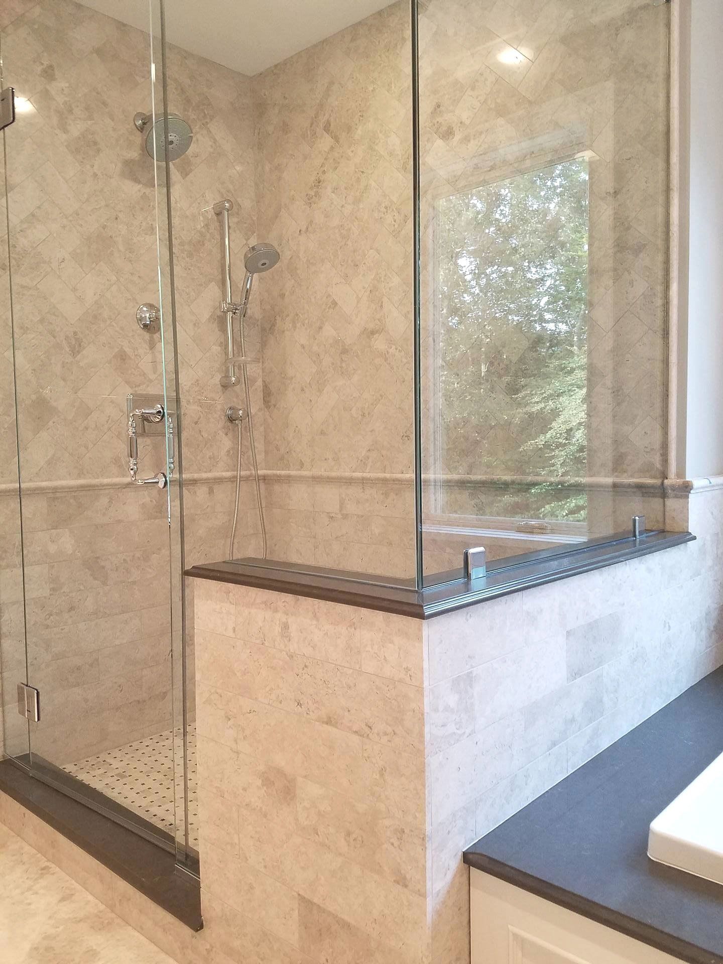 A bathroom with a walk in shower and a window.
