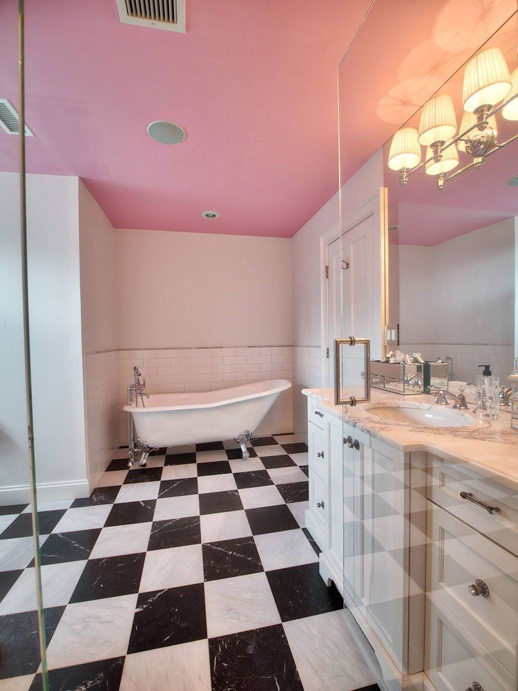 A bathroom with a pink ceiling and black and white checkered floor