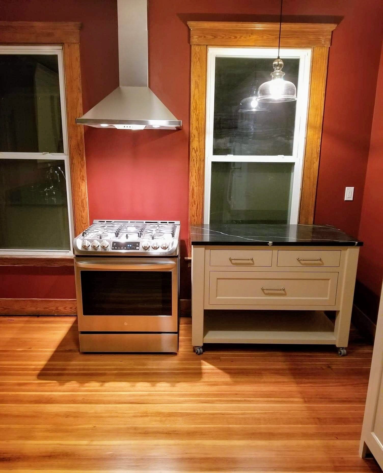 A kitchen with a stove top oven and a window