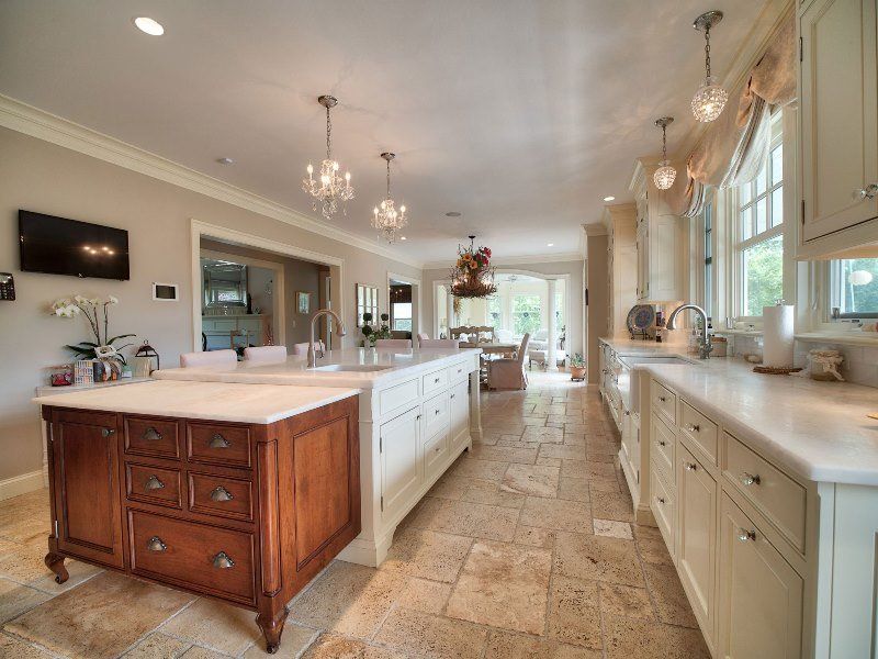 A kitchen with white cabinets and a large island in the middle.