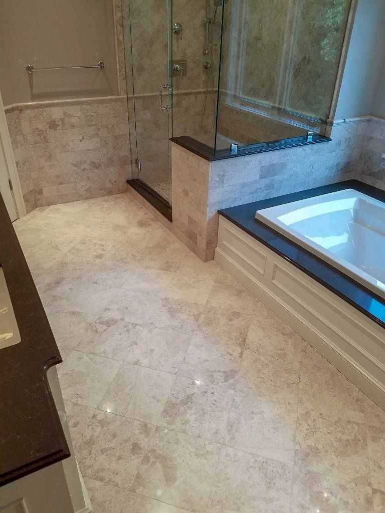 A bathroom with a tub , shower , sink and mirror.