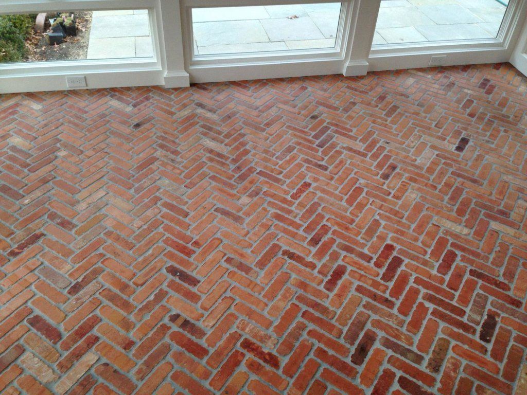 A brick floor with a herringbone pattern in a room