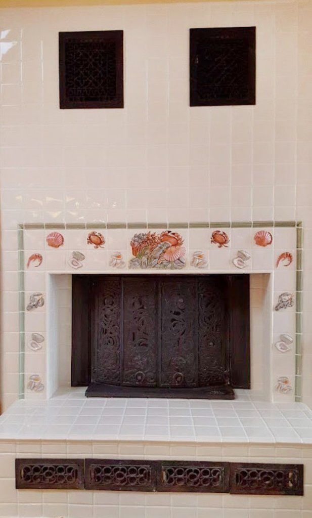 A fireplace with a tiled mantle and a door in a living room.