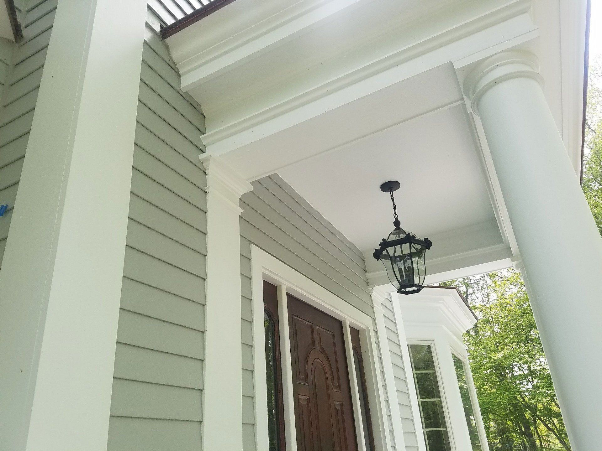 A porch with a lantern hanging from the ceiling