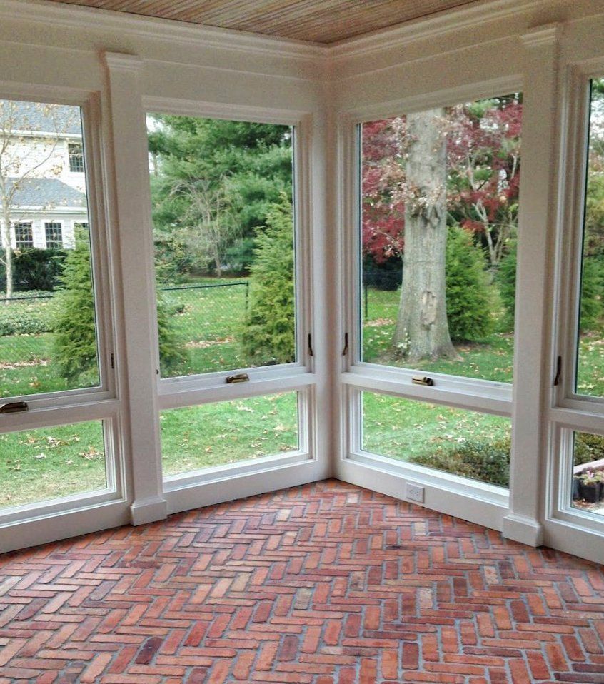 A room with a brick floor and lots of windows