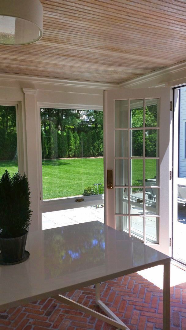 A room with a table and a window with a view of a yard.