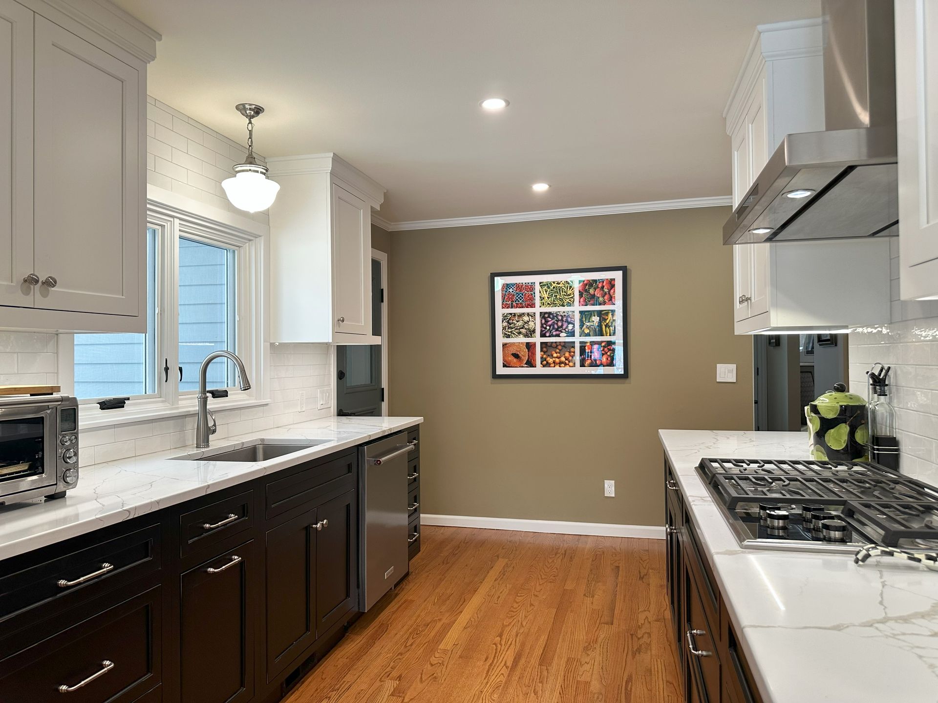 A kitchen with a picture on the wall above the stove