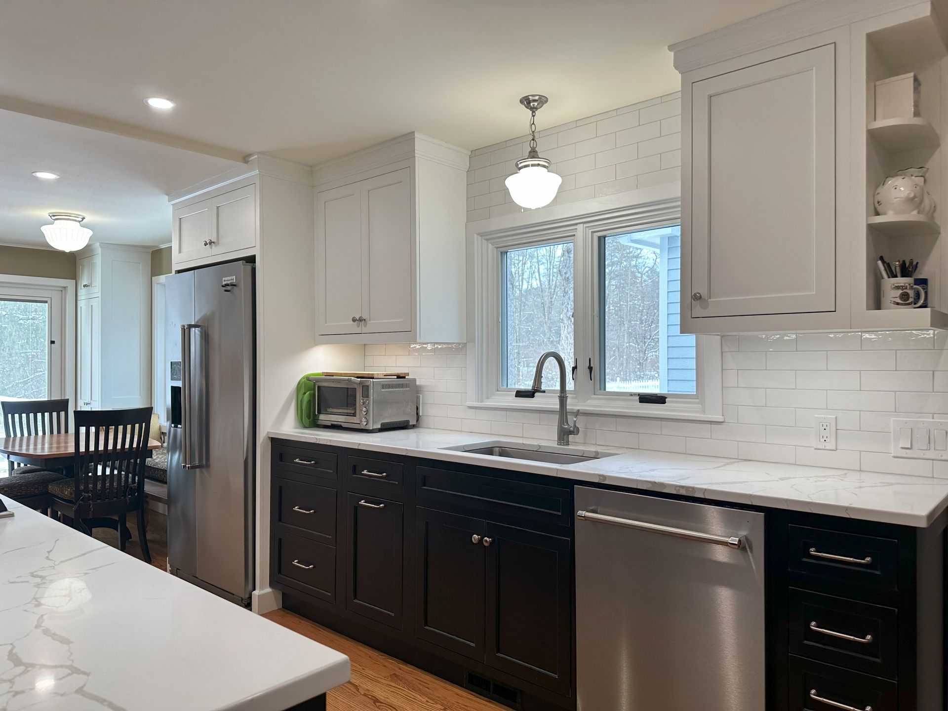 A kitchen with black and white cabinets and stainless steel appliances