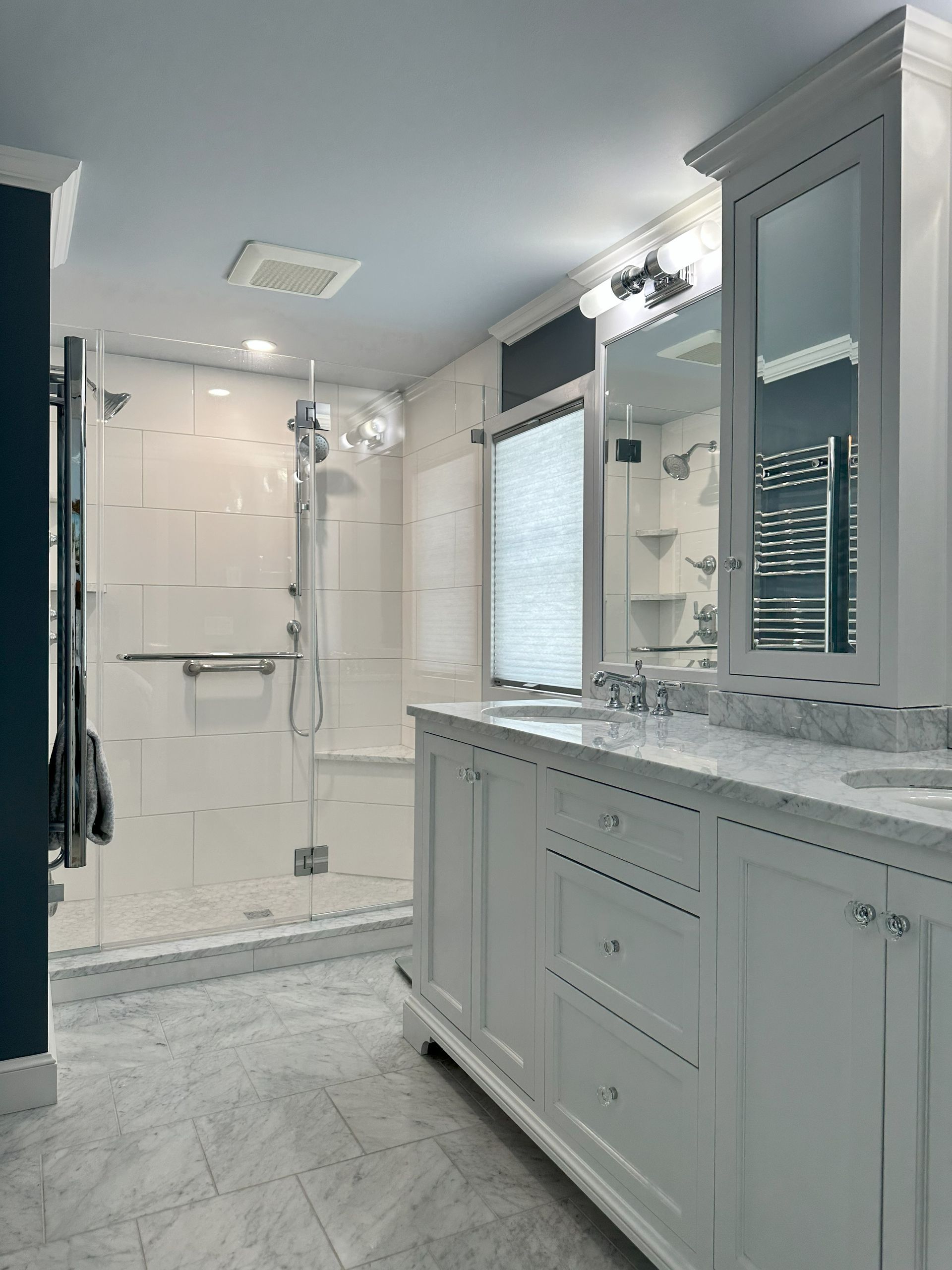 A bathroom with a walk in shower , sink and mirror.