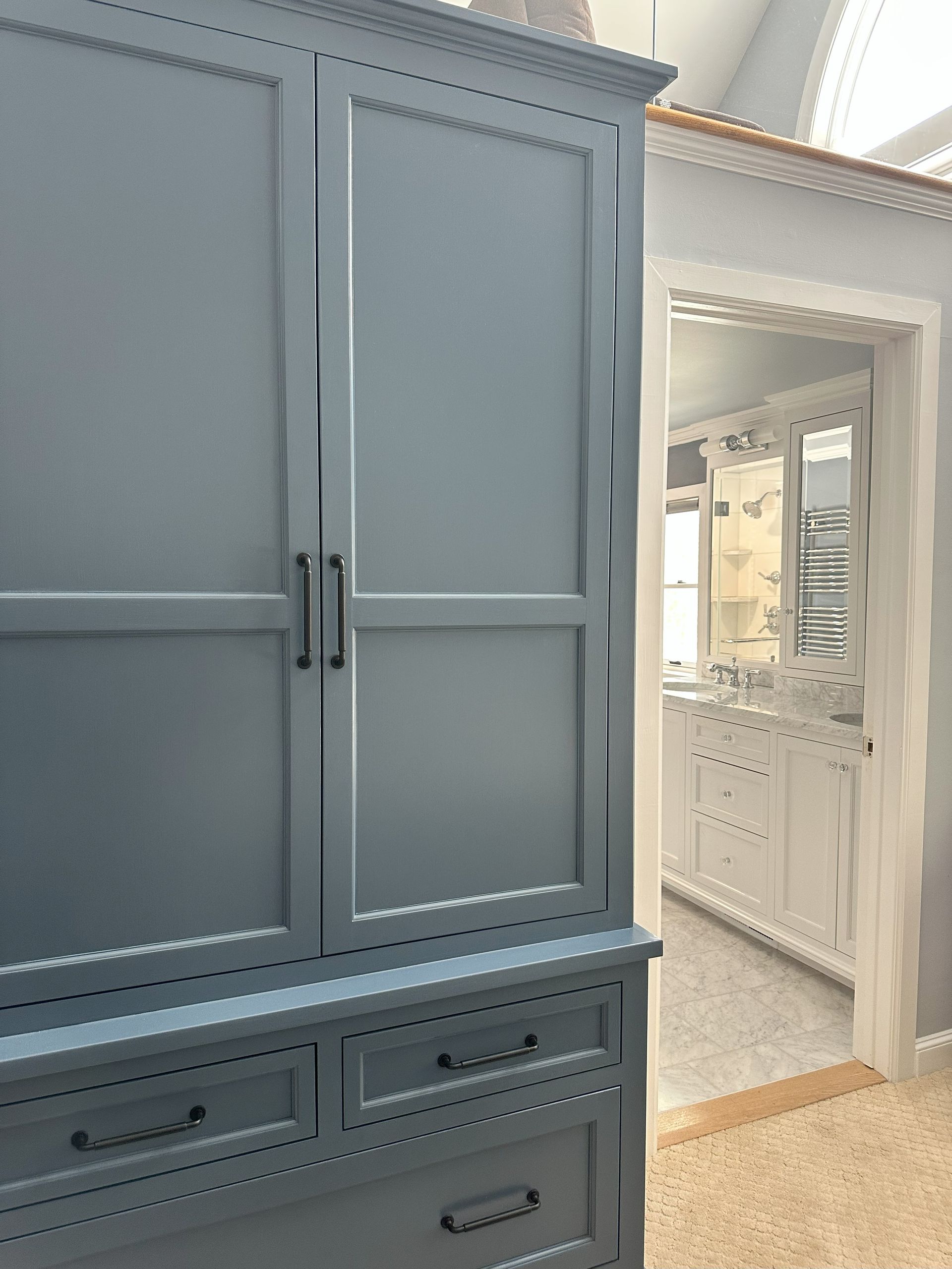 A bathroom with a blue cabinet and white cabinets