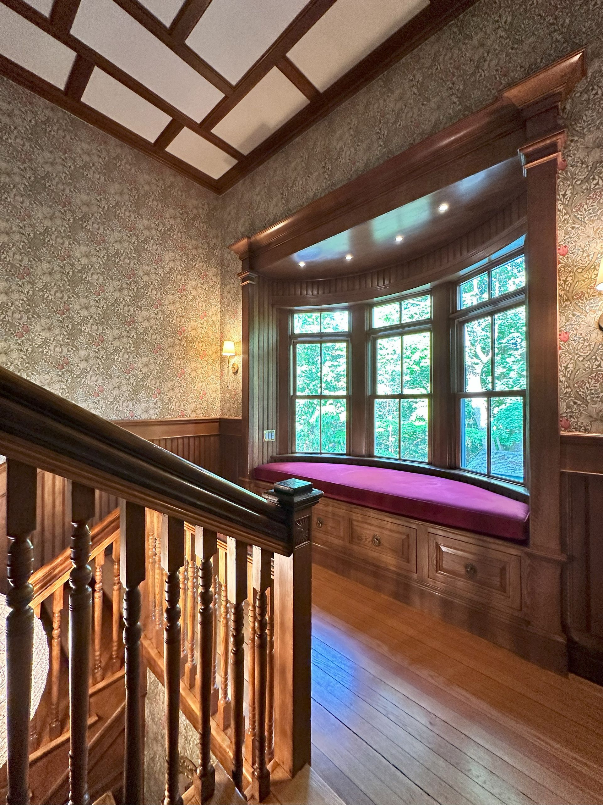 A wooden staircase with a window seat in the middle of it