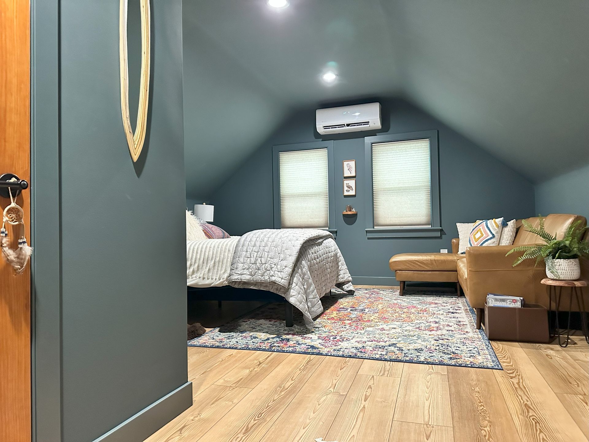 A bedroom with a bed , couch , and rug.