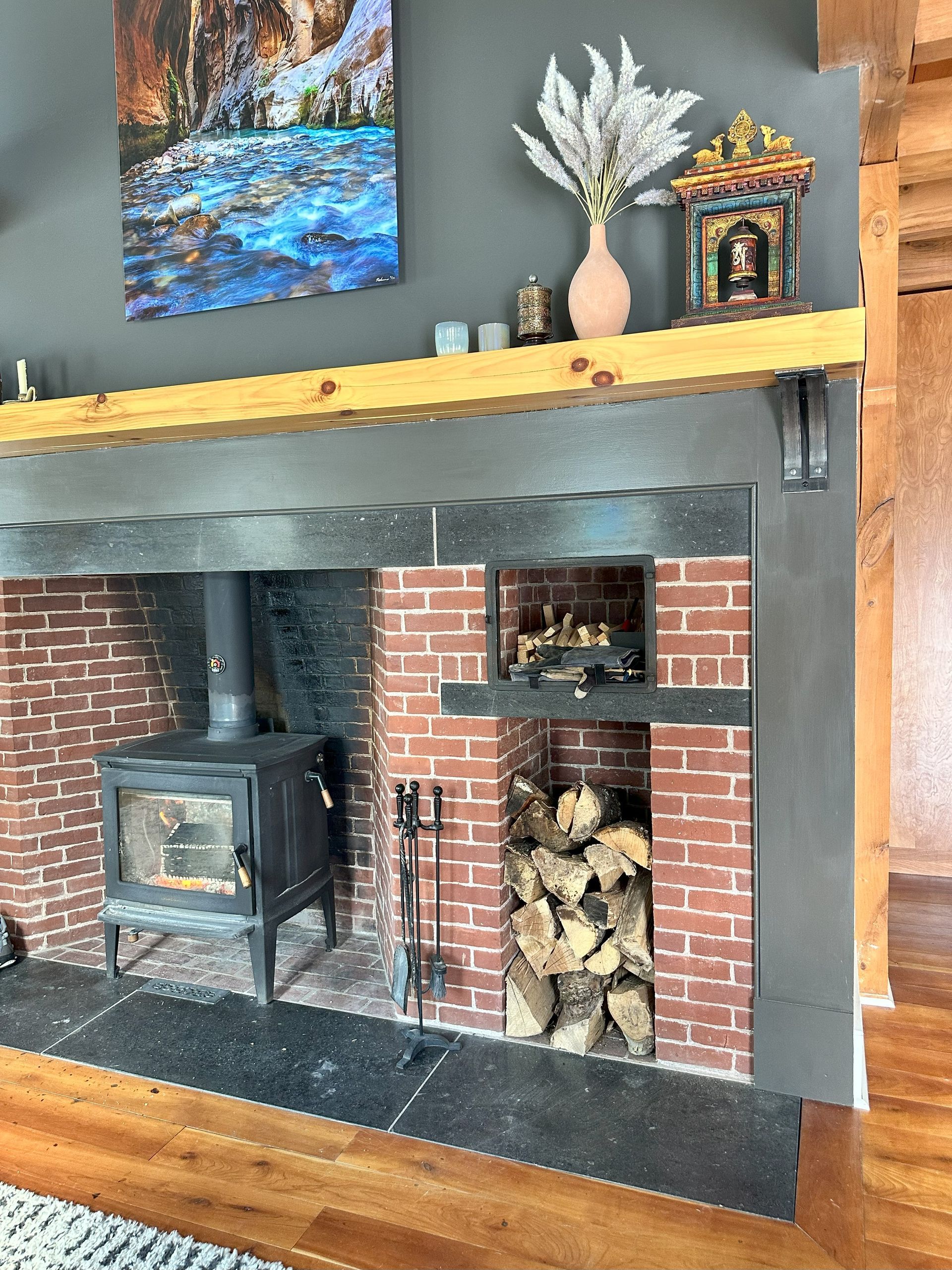 A living room with a brick fireplace and a wood stove.