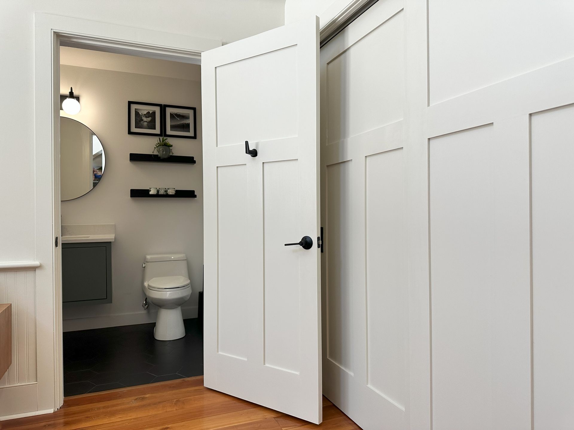 A bathroom with a toilet , sink and mirror.