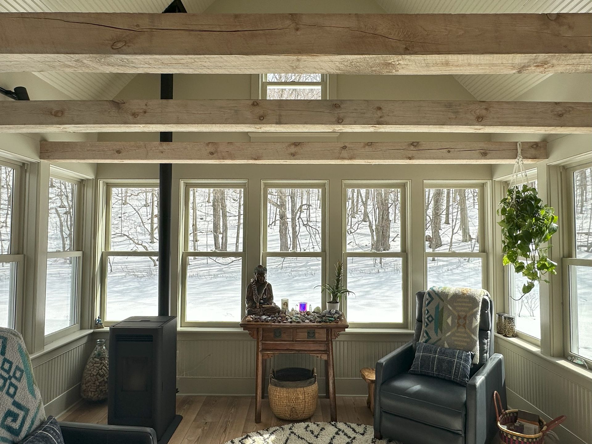 A living room with a lot of windows and a fireplace.