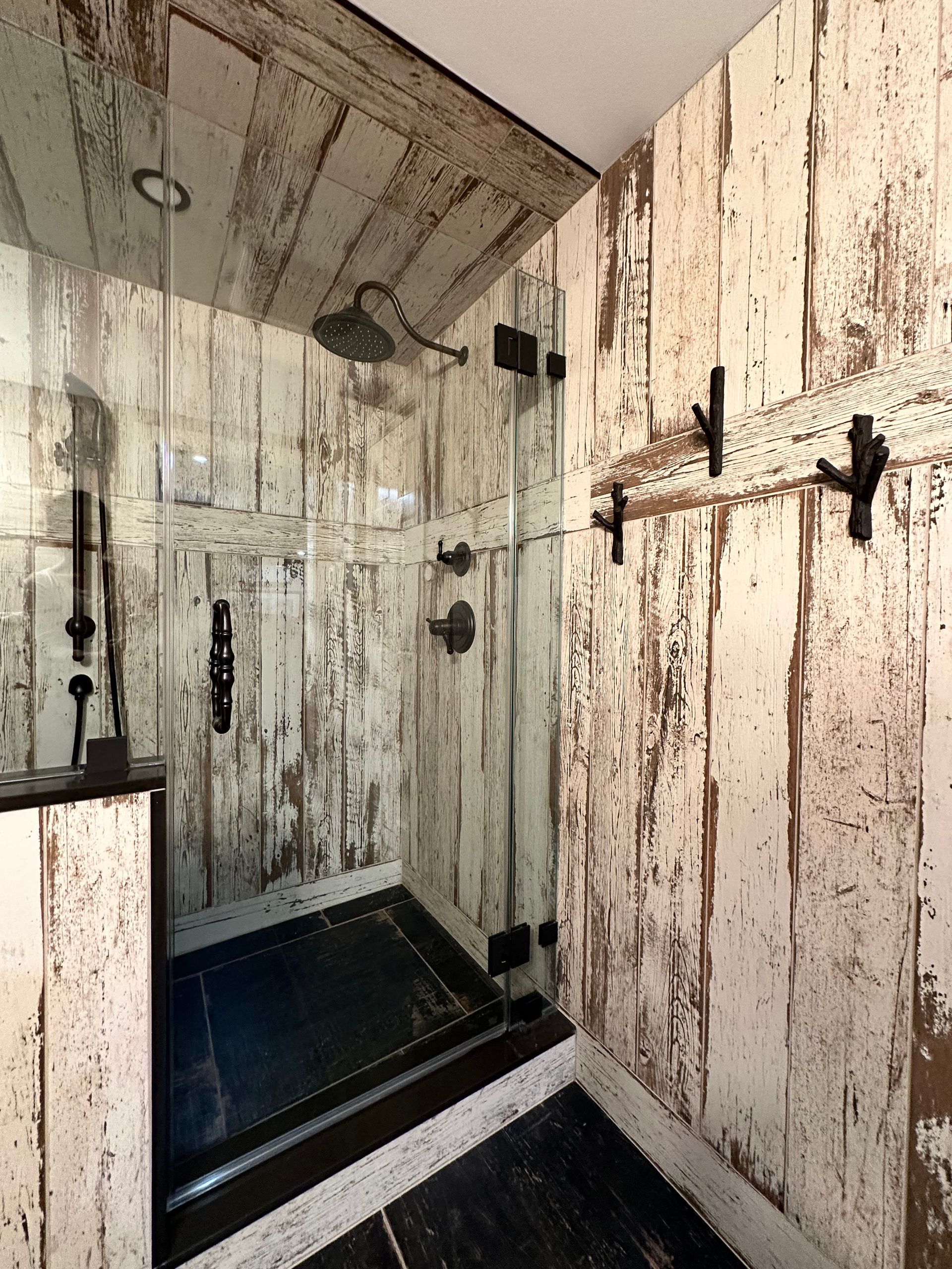 A bathroom with a walk in shower and wooden walls