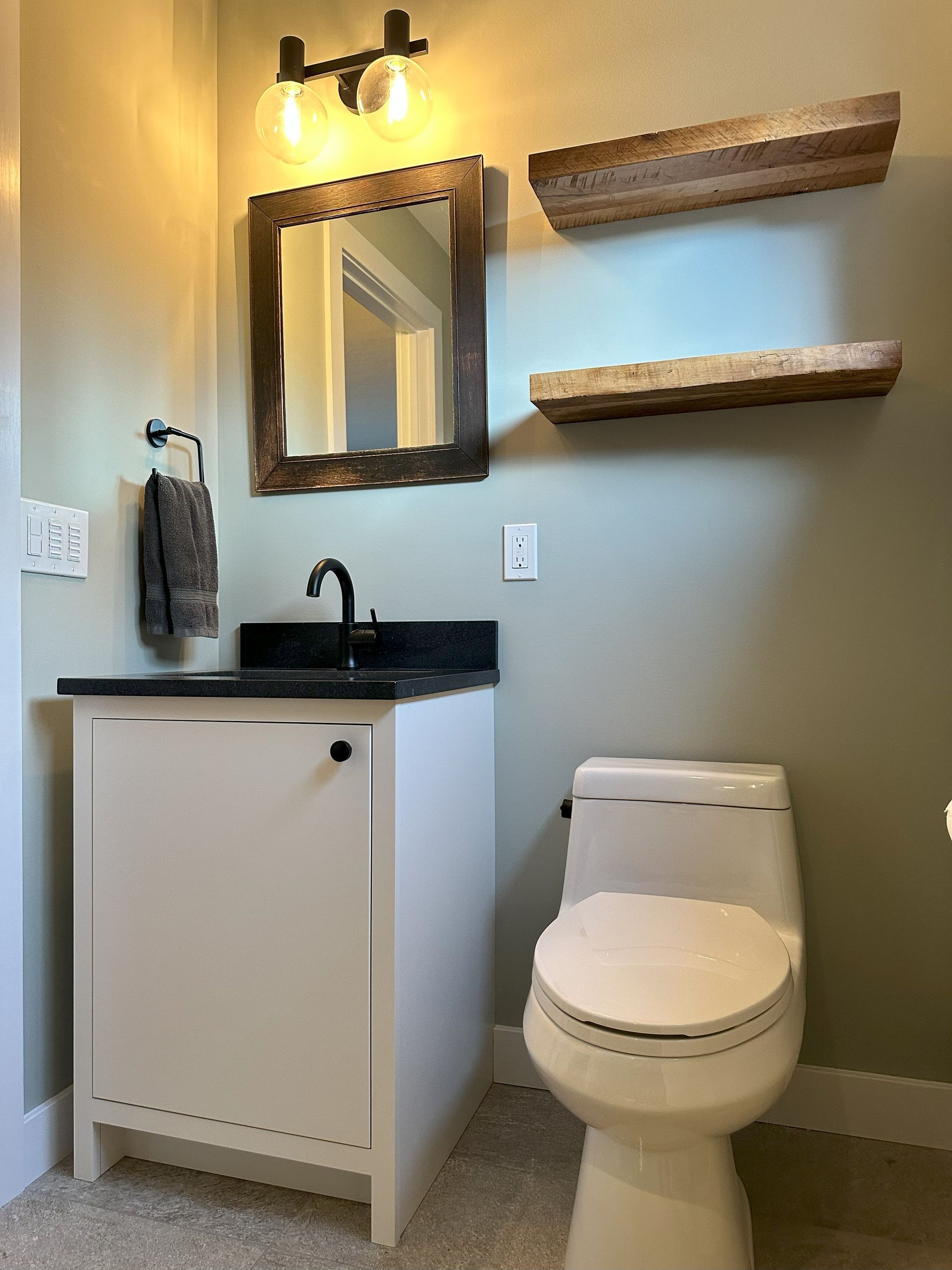 A bathroom with a toilet , sink and mirror