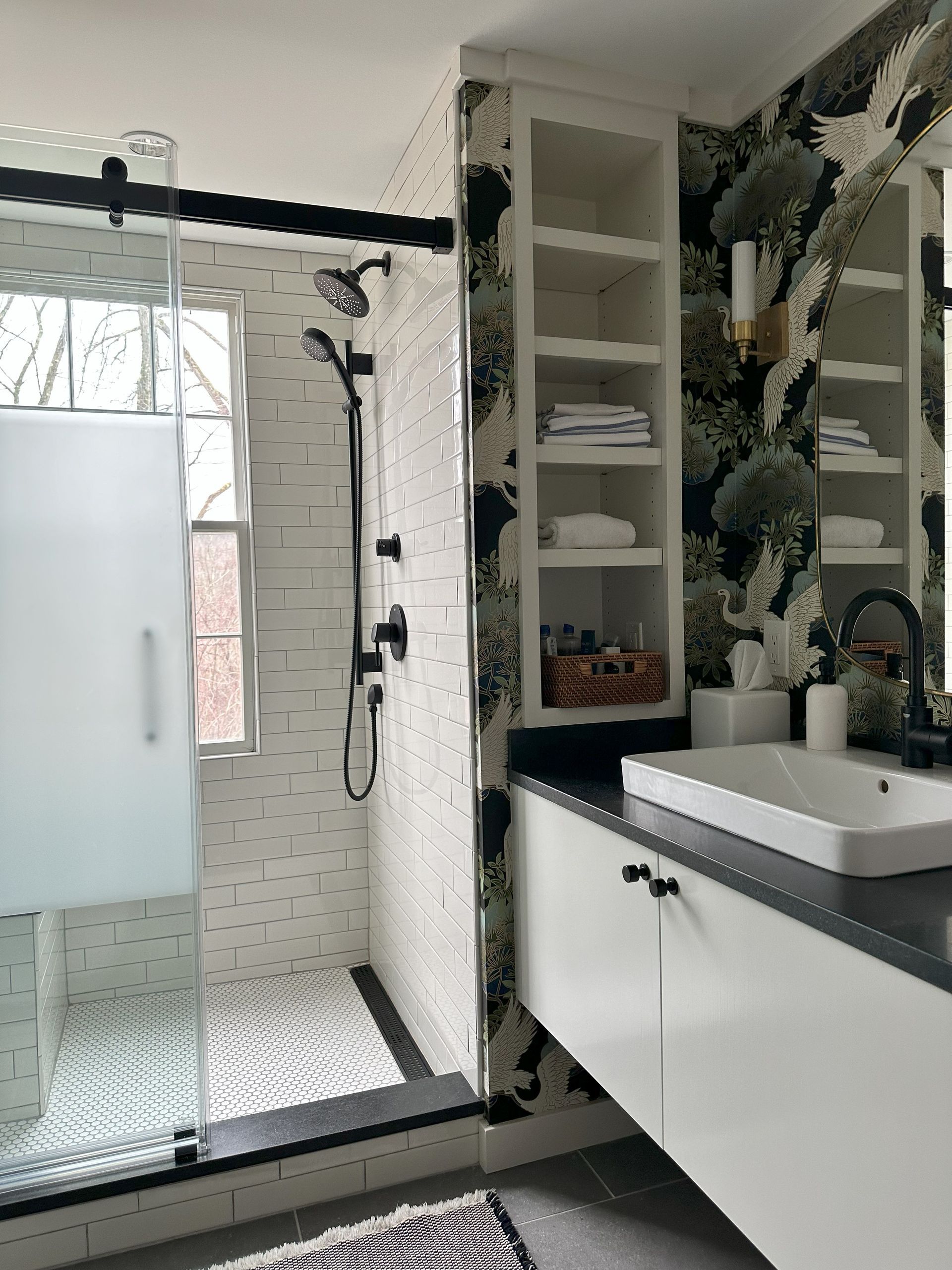 A bathroom with a sink , shower , and mirror.