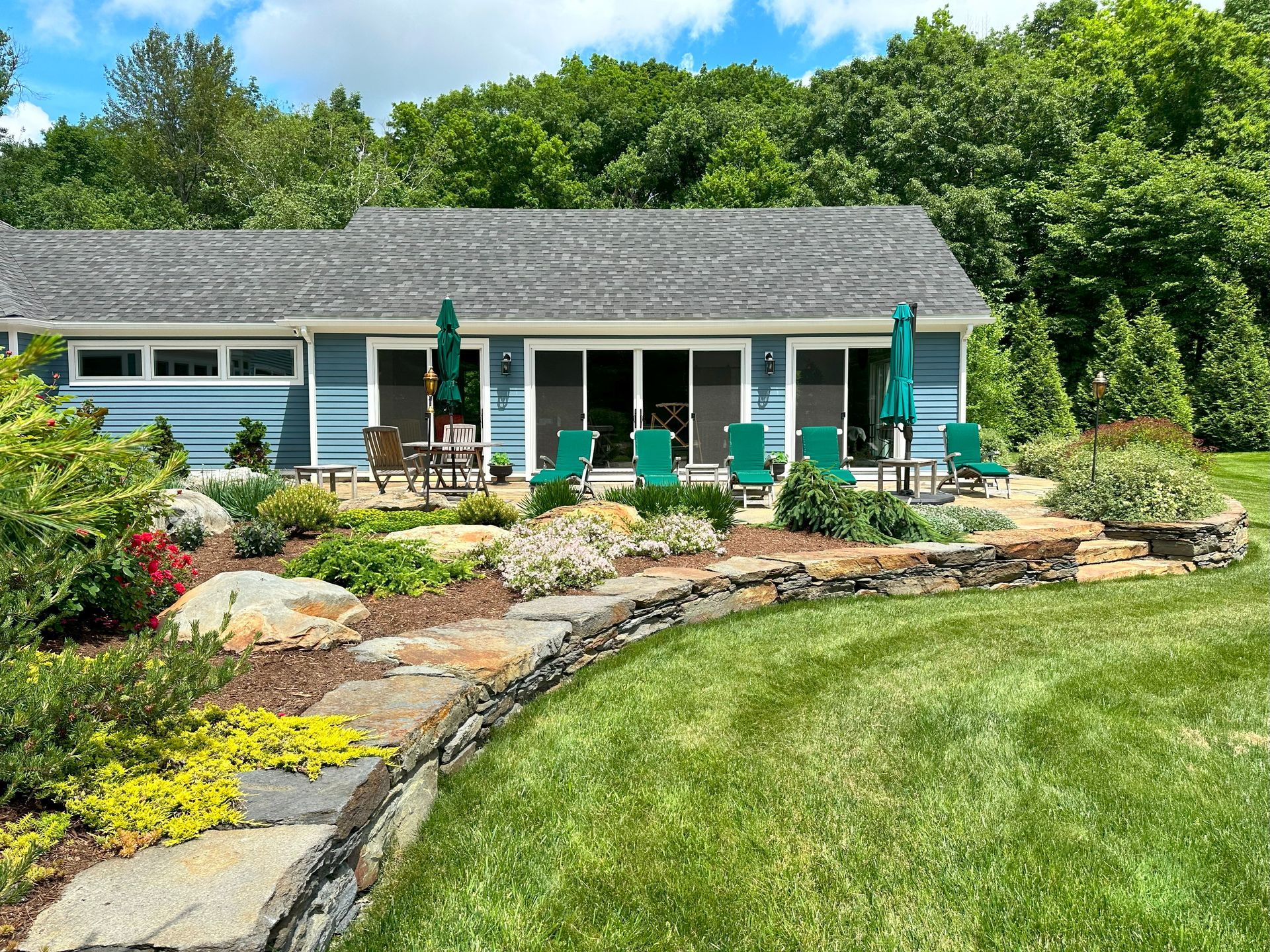 A blue house with a large lawn in front of it