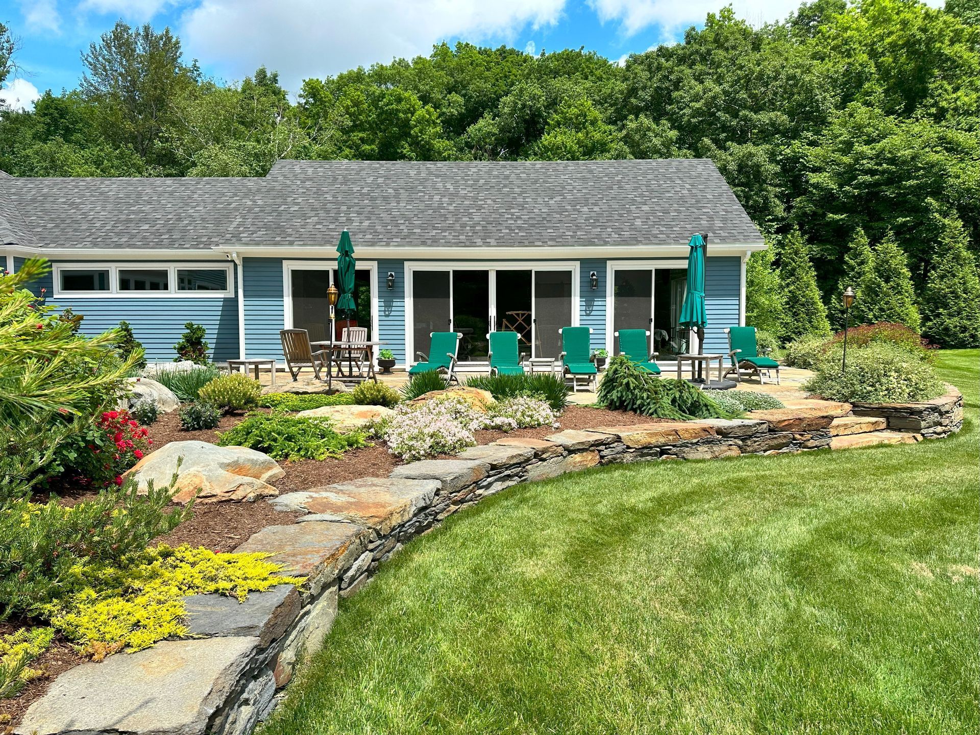 A blue house with a large lawn in front of it