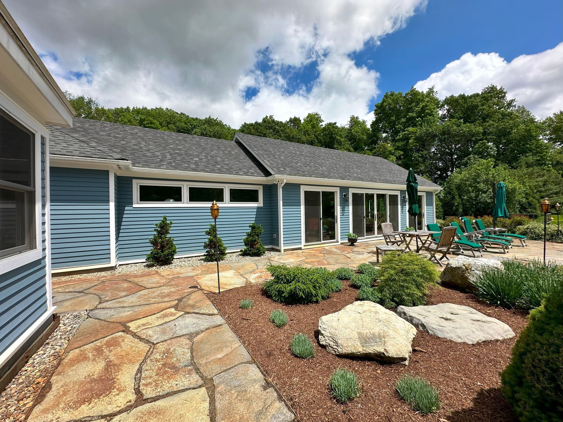A large blue house with a patio in front of it