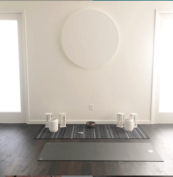 There is a yoga mat on the floor in the middle of the room.