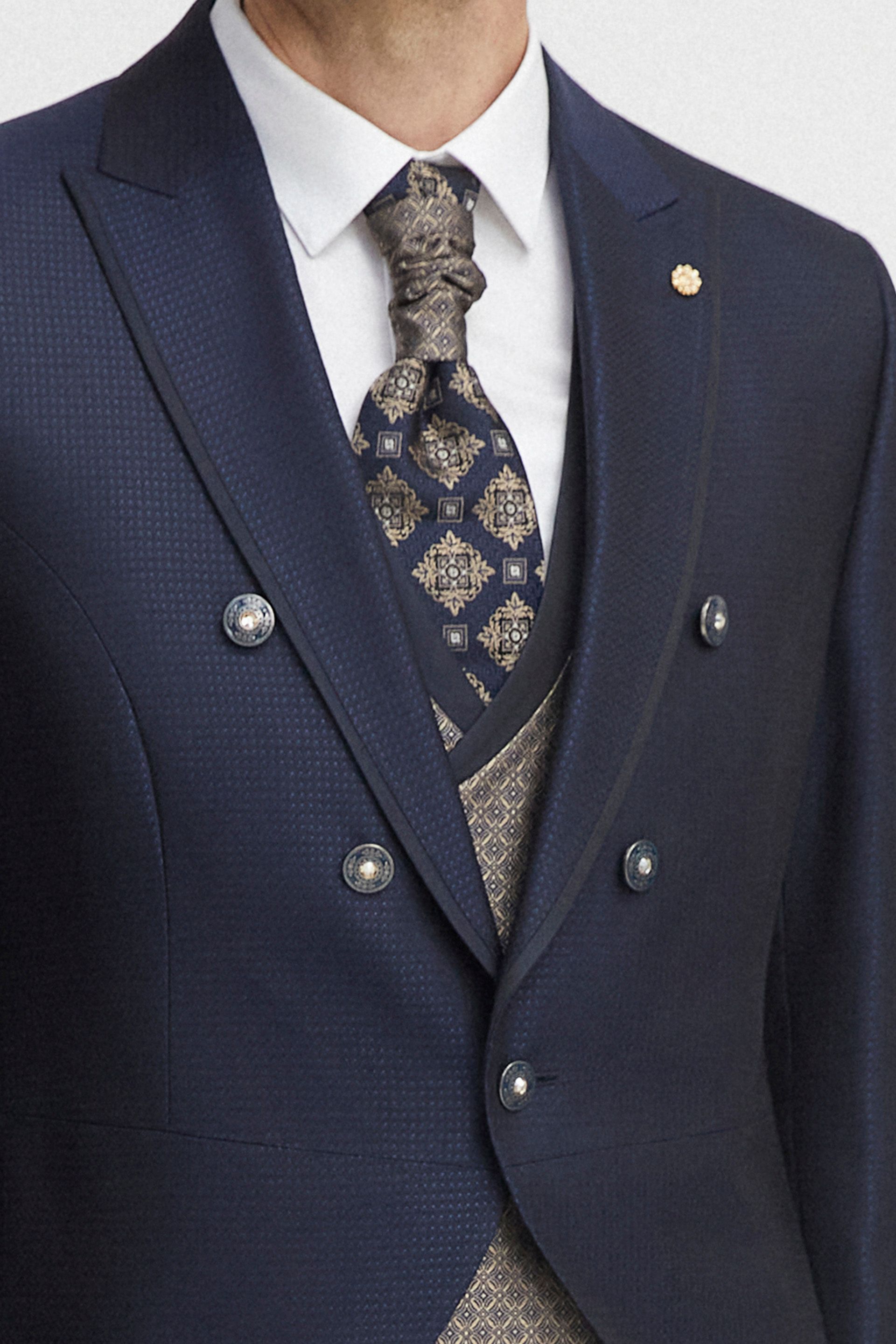 Un uomo indossa un abito blu e una cravatta