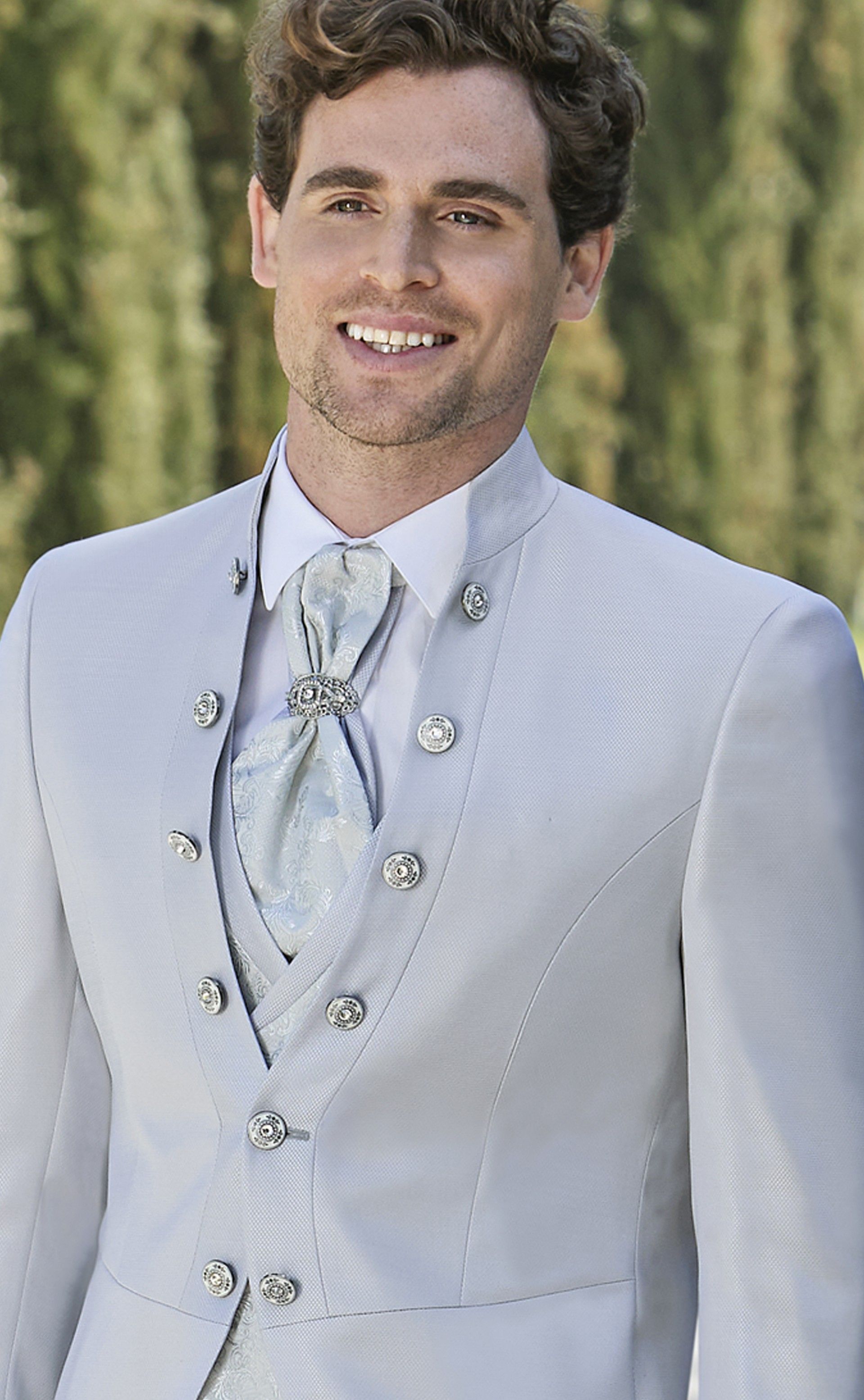 Un uomo in giacca e cravatta sorride alla telecamera.