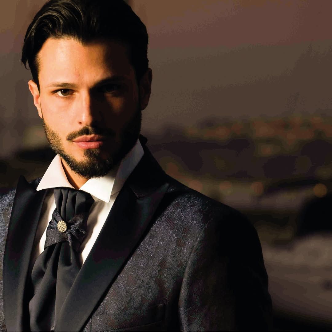 Un uomo con la barba indossa uno smoking e una cravatta